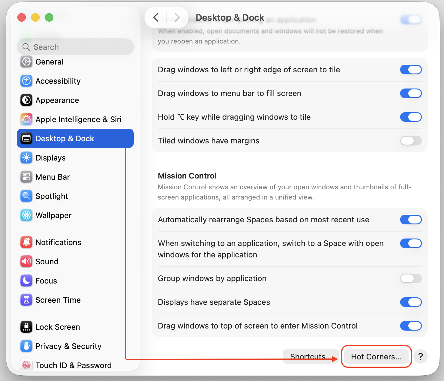 The Desktop & Dock pane in macOS Tahoe System Settings with the Hot Corners button highlighted at the bottom on an Apple computer.