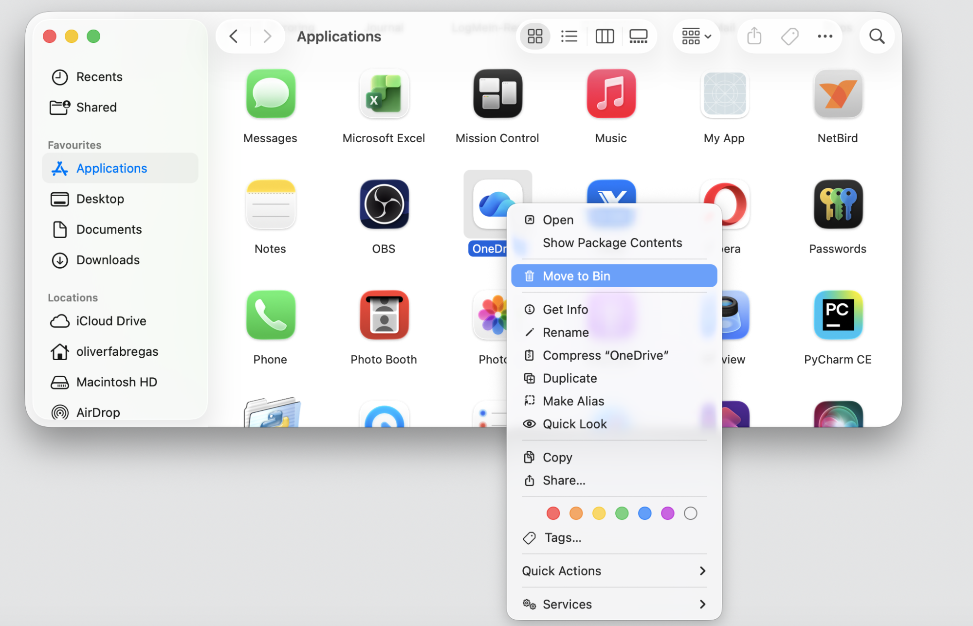 Finder right-click menu on the OneDrive app on macOS with Move to Bin selected to uninstall OneDrive before reinstalling on a MacBook.