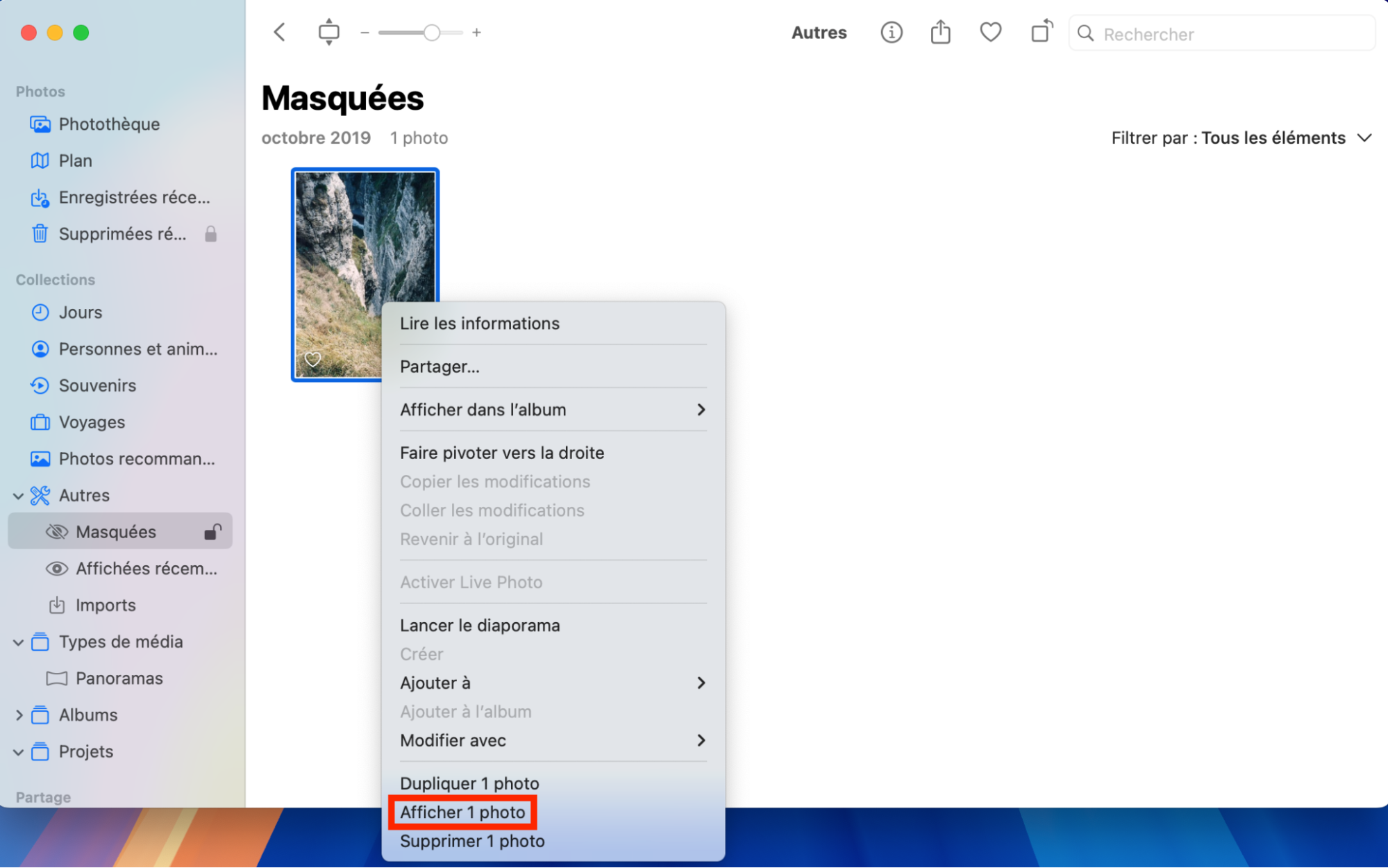 Pour trouver des photos masquées sur votre Mac, allez dans Photos, cliquez sur Masquées, et sélectionnez Afficher l’album.