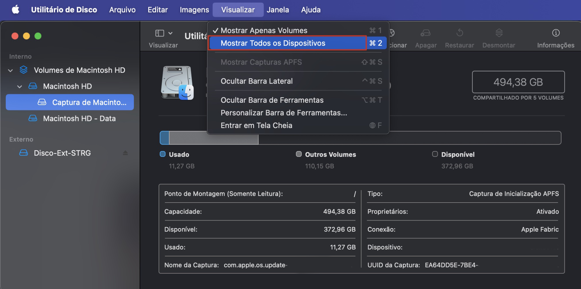 A opção Mostrar Todos os Dispositivos está destacada em vermelho via opção Visualizar do Utilitário de Disco na barra de menus. O Utilitário de Disco permite aos usuários redefinir o Mac às configurações de fábrica.