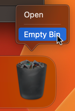 A close up of the macOS Dock showing the Trash icon with a full bin appearance indicating it contains files. A context menu is open above it with two options Open and a highlighted blue Empty Bin option with a cursor hovering over it.