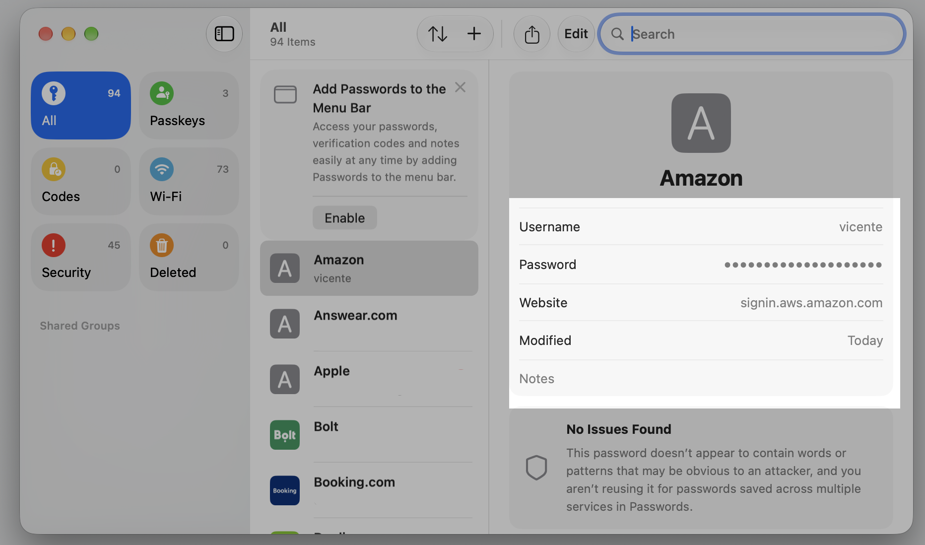 A selected entry in the Passwords app on a MacBook, showing the full username and password stored in iCloud Keychain for that site.