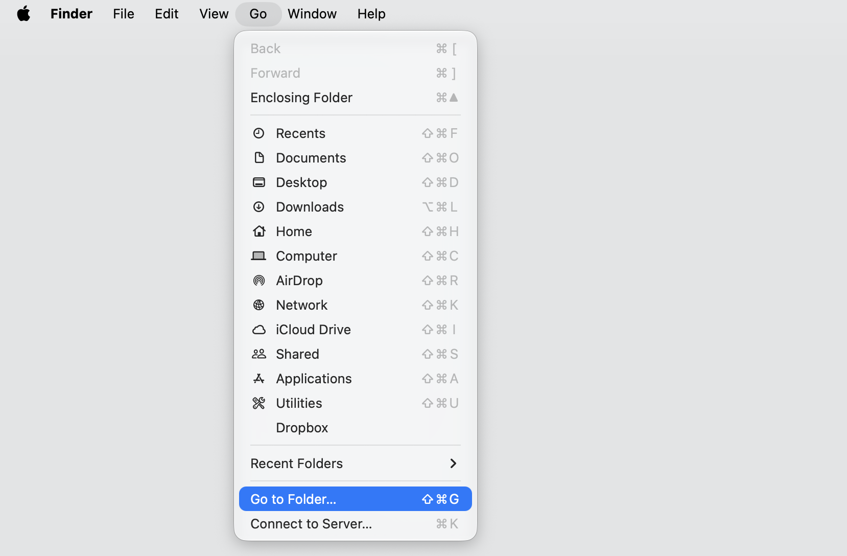 The Finder Go menu open on a MacBook, with Go to Folder highlighted to reach the hidden Library folders holding Atlas leftovers.