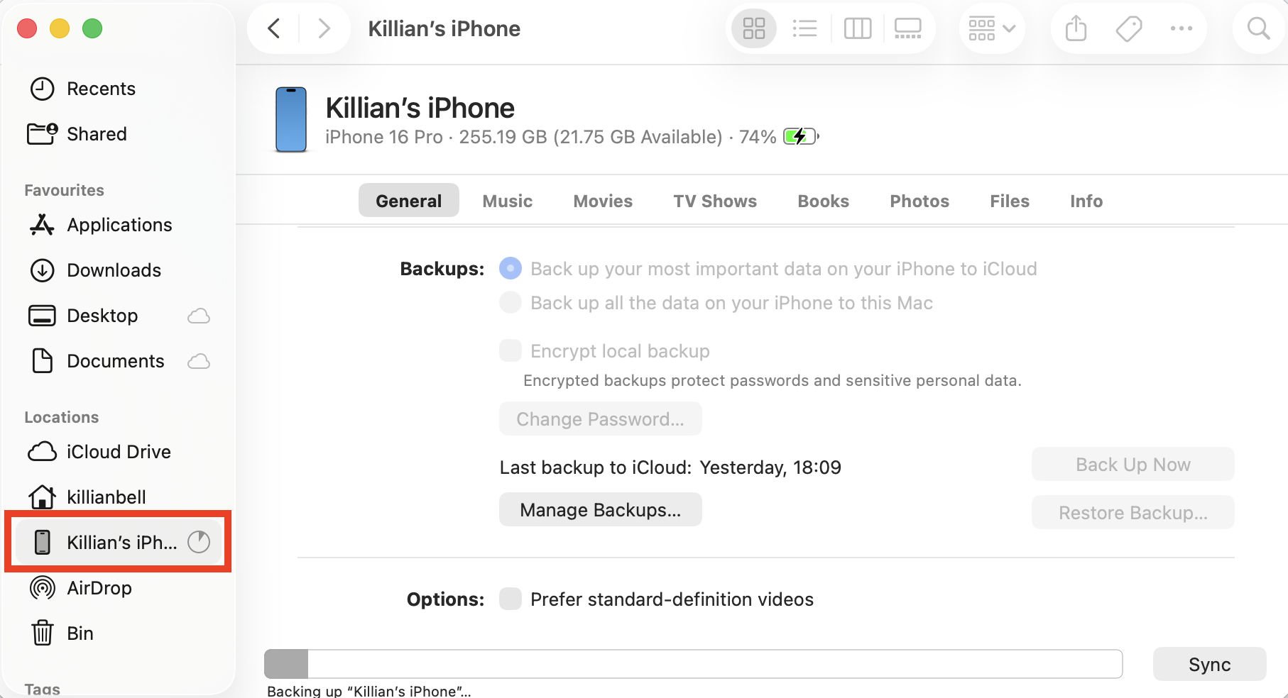 An iPhone in the Finder sidebar on Mac. To delete iOS files when they're taking up too much space, plug in your iPhone or iPad, select it in Finder, then delete all backups.