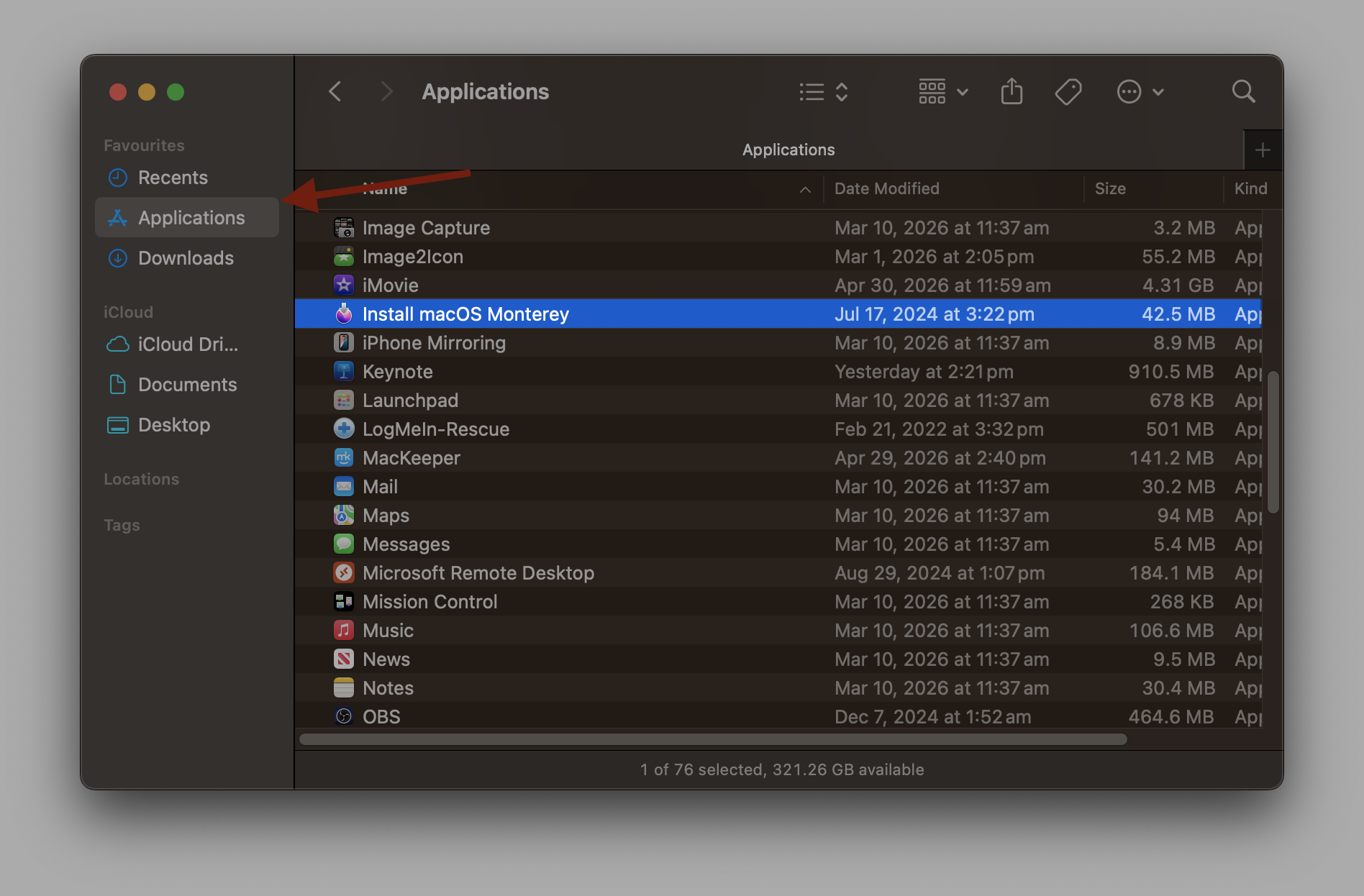 A Finder window in list view with the Applications folder selected in the left sidebar. In the main panel the file Install macOS Monterey is highlighted in blue. A red arrow points to the file name.