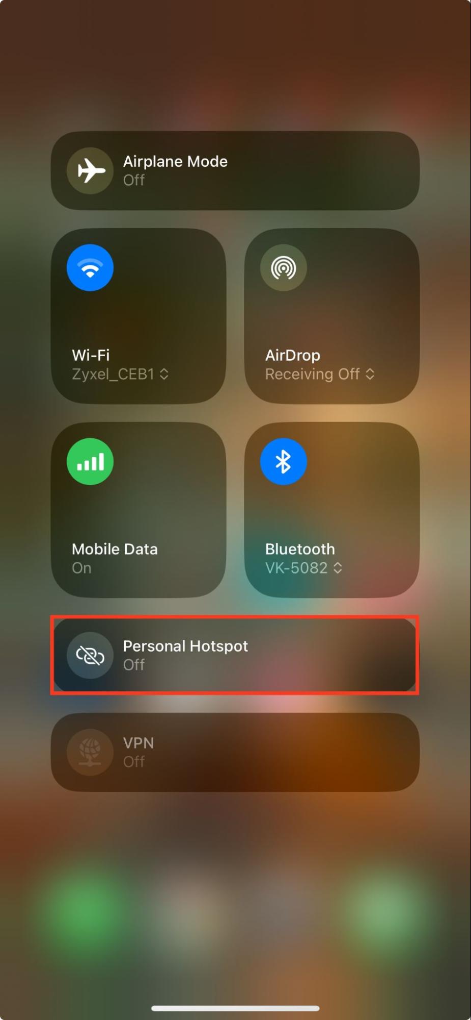 The Control Center appears on an iPhone screen. Swipe down to reveal it and disable your personal hotspot to fix AirDrop waiting.