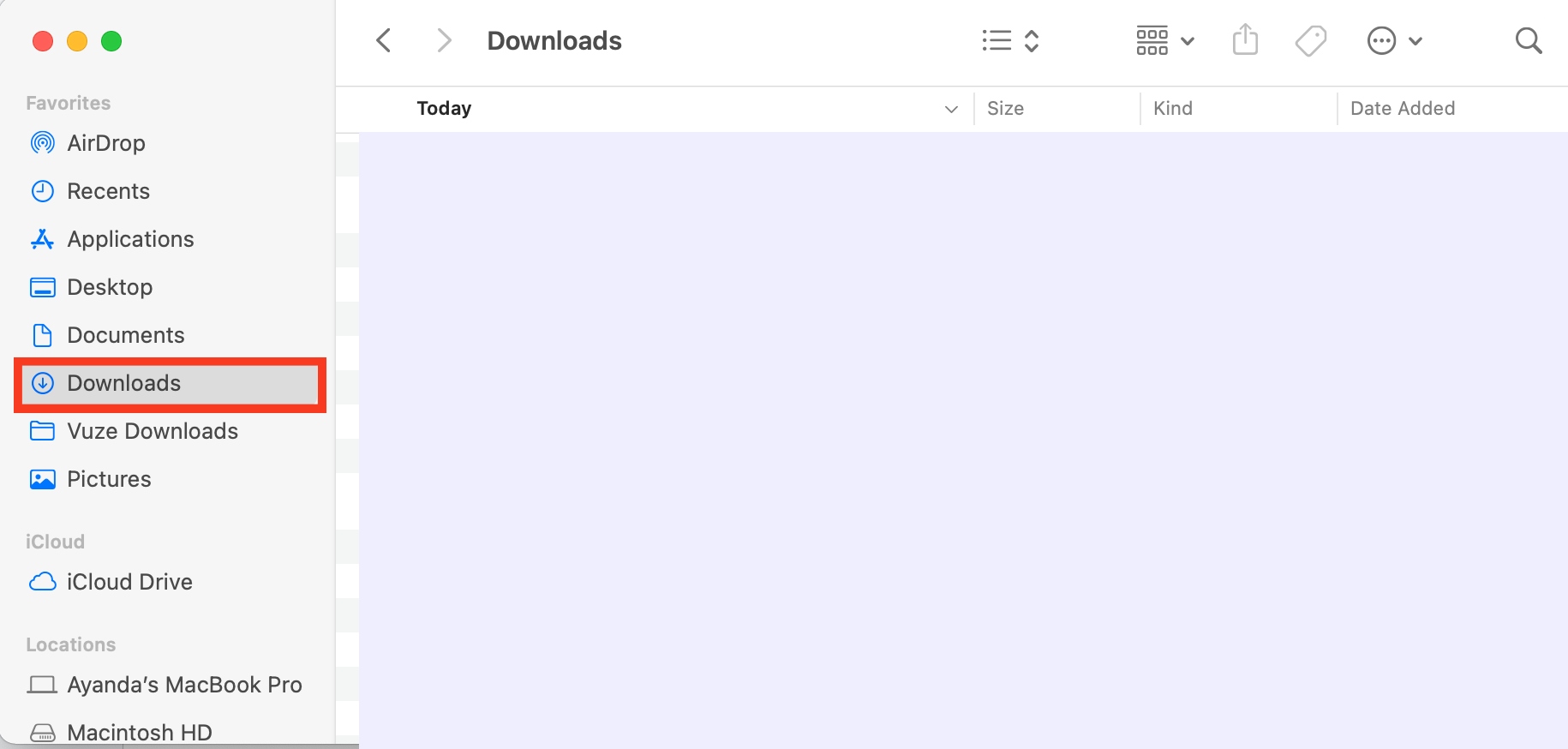 Finder is opened on a MacBook. In Finder, you’ll find the Downloads folder that contains your AirDropped photos and other files.