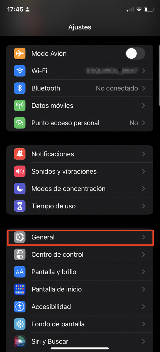 La aplicación Ajustes del iPhone muestra una lista de opciones del sistema. Selecciona General para restablecer de fábrica el dispositivo.