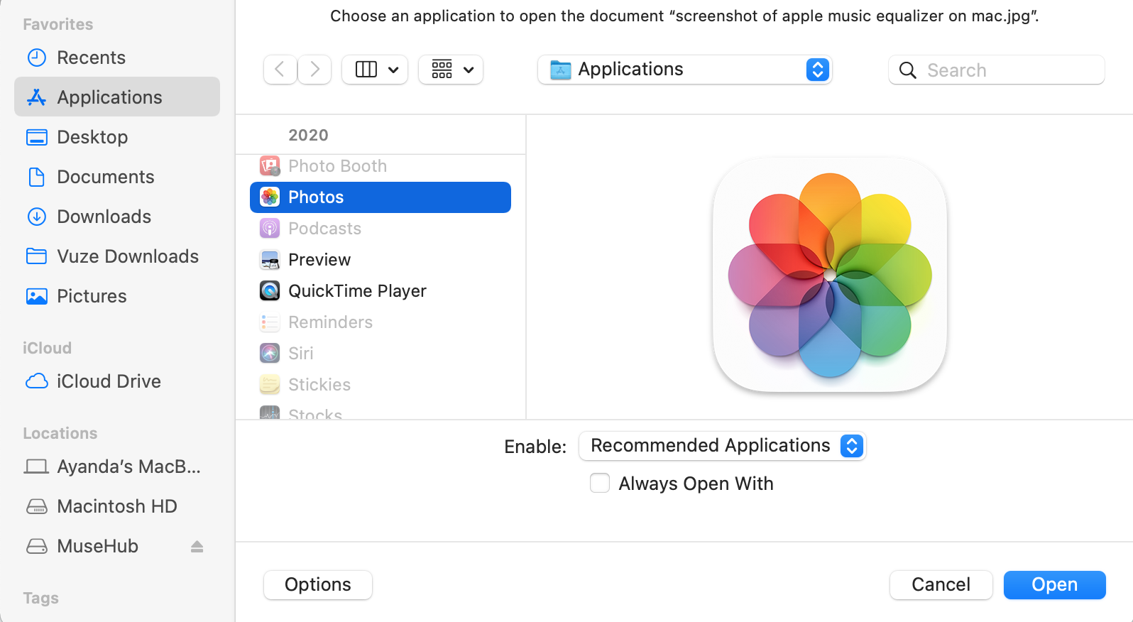 Finder is opened on a MacBook computer. Right-click on the photo you want to open and select Open with > Photos to find AirDropped photos.