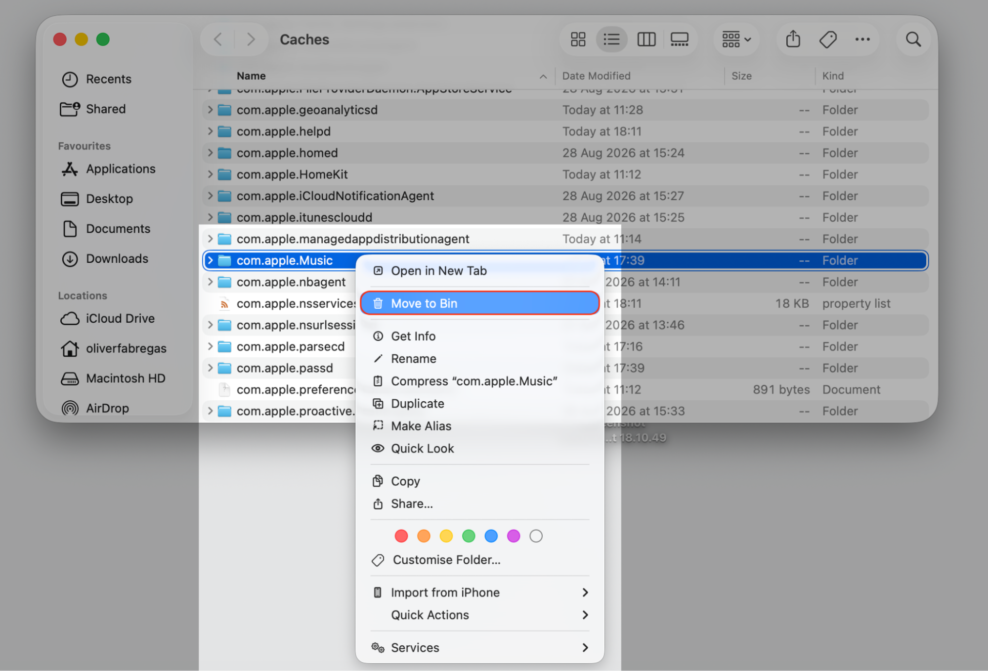 Finder Caches folder on an Apple device with the com.apple.Music folder right-clicked and Move to Bin selected to clear Apple Music cache.