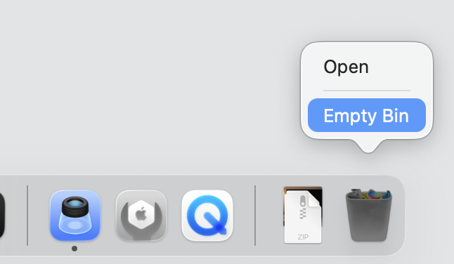 Dock on macOS with the Bin icon right-clicked and Empty Bin highlighted to permanently remove deleted Apple Music files and free disk space.