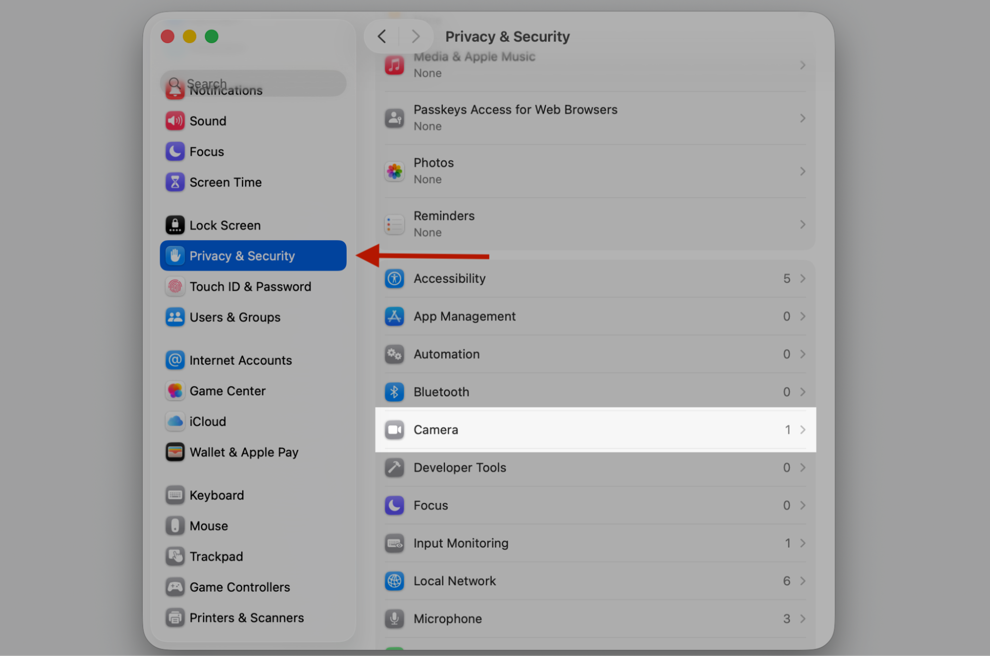 macOS System Settings window with Privacy & Security selected and Camera highlighted to review app camera permissions on a MacBook.