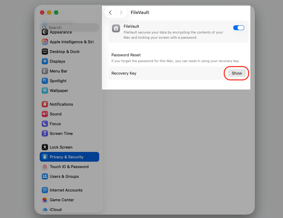 The FileVault pane in macOS Privacy & Security settings with the Show button beside Recovery Key highlighted on an Apple computer.