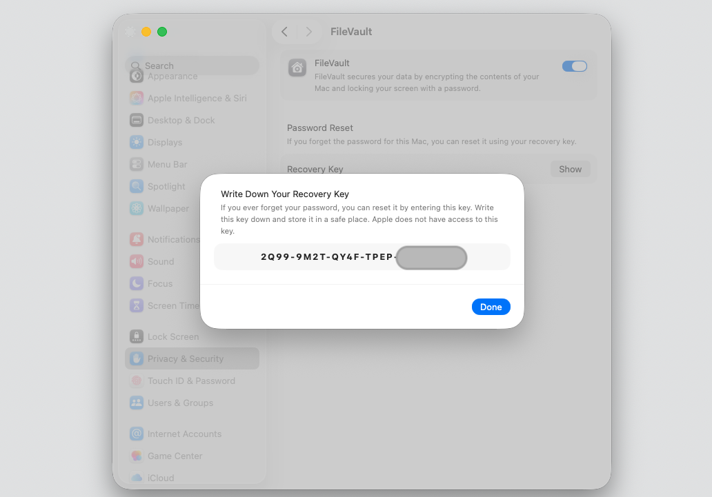 The Write Down Your Recovery Key dialog in macOS FileVault settings displaying the Mac Recovery Key to save outside your Apple device.