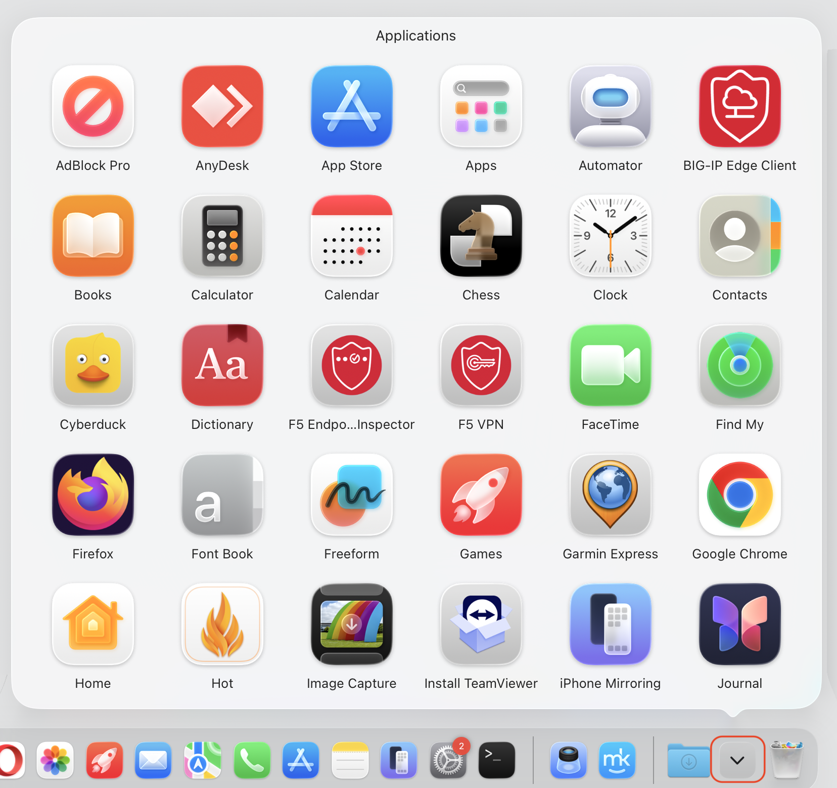 The Applications folder pop-up grid opened from the Dock on macOS Tahoe, showing all apps as a Launchpad replacement on a MacBook.