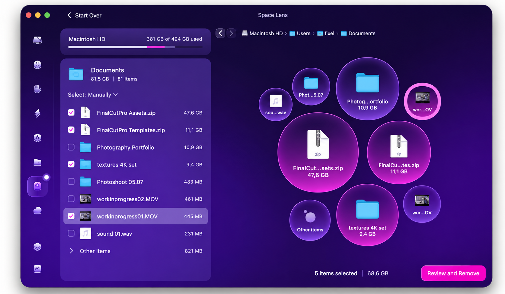 CleanMyMac Space Lens tab on a MacBook, mapping large Documents folder files as bubbles beside the Review and Remove cleanup button.